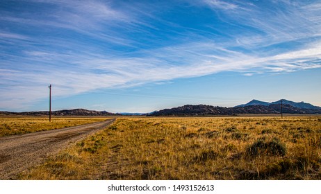 Agate Flat Road, Granite Mountains, Wyoming With Sage Covered Prairie, White Morning Clouds And Telephone Pole