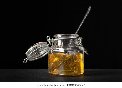 agave syrup in glass jar with spoon inside. black background - Powered by Shutterstock