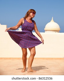 Age Doesn't Matter - Tanned, Fit Middle-aged Woman Dances On The Subroof In Short Flared Dress