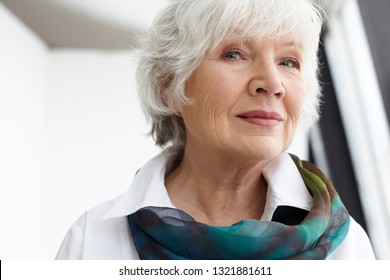 Age, Maturity, Beauty, Style And Fashion Concept. Close Up Image Of Classy Stylish Senior Mature Woman With Wrinkles, Gray Hair And Natural Make Up Spending Leisure Time Indoors, Smiling At Camera