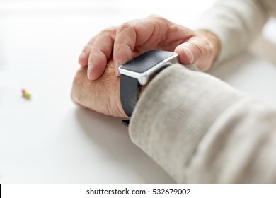 age, medicine, healthcare and people concept - close up of senior man hand with pill and smart watch - Powered by Shutterstock