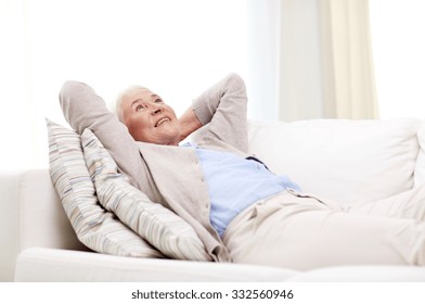 Age, Relax And People Concept - Happy Smiling Senior Woman Resting On Sofa And Dreaming At Home