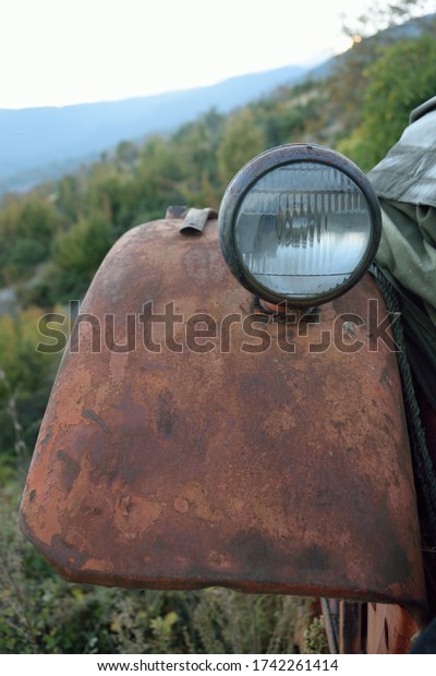 Age of rusted Trecker, put down on a meadow in\
mountain landscape tell about the old agrarian culture.\
Weather-beaten vehicle from metal, colour has flaked off,\
agricultural old-timers wait for\
repair