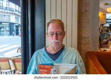 Age, Tourism, Travel And People Concept - Senior With Map And City Guide Of Paris, Sitting In Cafe. 