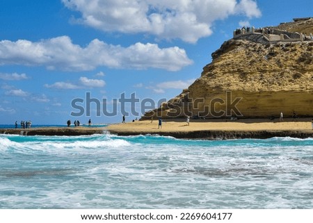 agebah beach scene and whitecaps with rocks cliffs at marsa matrouh mesir in daylight