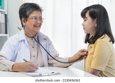 Aged Asian Physician Psychiatrist, General Woman Doctor Consulting Concerned With Teenage Girl, Child Patient  Explaining Diagnosis, Appointment At Clinic, Hospital. Health Care, Check Up Medical.