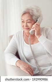 Aged Asian woman talking on the phone