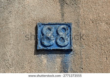Aged blue number eighty eight sign with cracked peeling paint texture and copy space.