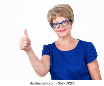 Aged Caucasian woman with thumb up looking at camera with smile, white background