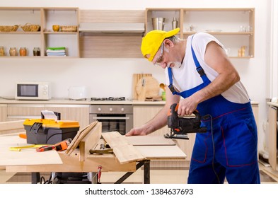 Aged contractor repairman working in the kitchen  - Powered by Shutterstock