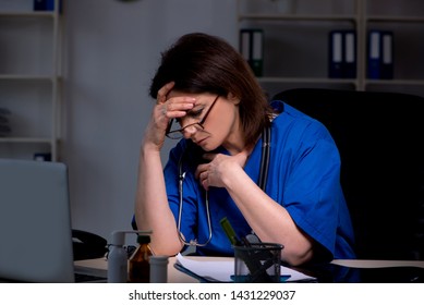 Aged Female Doctor Working At Night Shift 