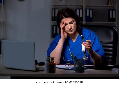 Aged Female Doctor Working At Night Shift 