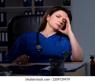 Aged Female Doctor Working At Night Shift