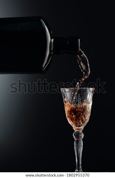 Aged golden fortified wine\
from the vintage bottle being poured into a crystal glass. Copy\
space.