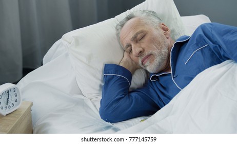 Aged male sleeping in bed in the morning, healthy sleep, recovery time, closeup