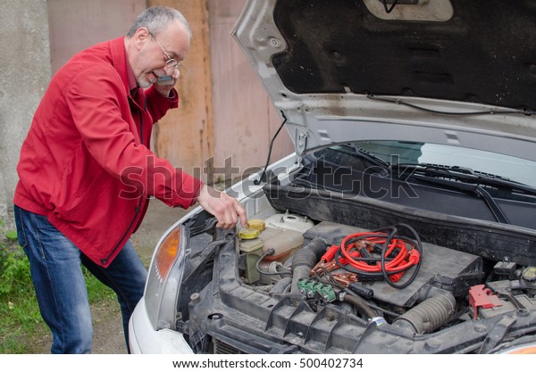 Aged man fixing the car
on the street
