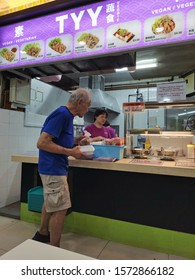 An Aged Man Receiving Free Servings Of Food From A Hawker In Singapore On 15th Nov 2019, 8pm