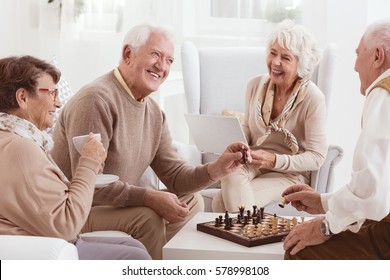 Aged people playing chess together in day-care center - Powered by Shutterstock