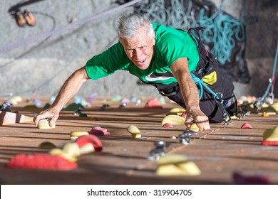 Aged Person Practicing Extreme Sport
Portrait Of Mature Male Climber Moving Up On Outdoor Climbing Wall Sporty Clothing On Fitness Training Intense But Positive Face Using Rope And Belaying Gear