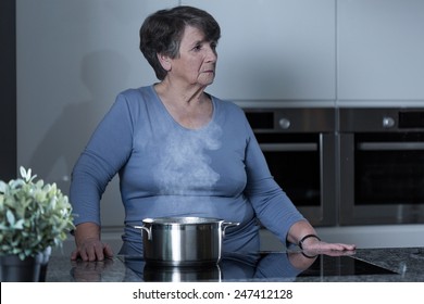 Aged Sad Woman Cooking In The Kitchen