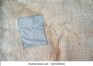 Aged Vintage And Weathered Cloth Background Texture With Patch. Old Damaged Brown Rough Texture 