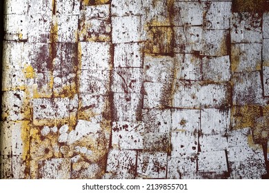 Aged and weathered white stone wall that has different size squares with mildew all over and deep crevices. Background texture.