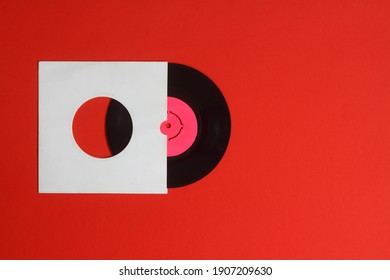 Aged White paper cover and vinyl LP record isolated on Red background. 45rpm Vinyl Record with Sleeve.
