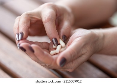 An Aged Woman Chose One Capsule From A Handful Of Medicines