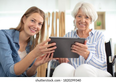 Aged Woman And Her Adult Daughter Using Tablet