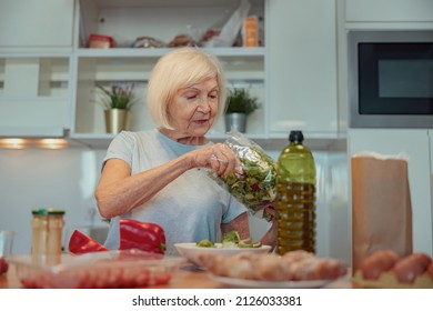 Aged Woman Making Salad At Home Kitchen