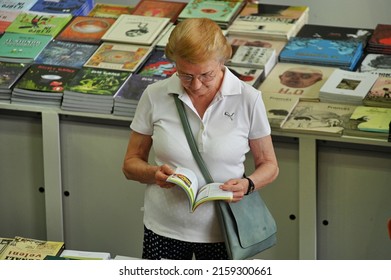 Aged Woman Reading A Book At Culture Festival Booth Turin Italy May 22 2022