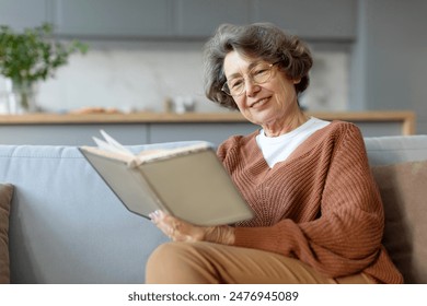 Aged woman sitting on couch and reading book pastime daydream, senior lady enjoying free time at home - Powered by Shutterstock