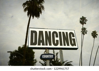 aged and worn country western dancing sign with palm trees                               