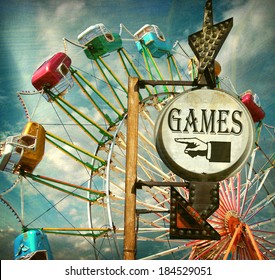 Aged And Worn Vintage Photo Of Carnival Games Sign With Ferris Wheel                              