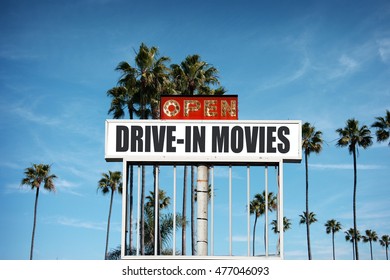 Aged And Worn Vintage Photo Of Old Drive In Movie Sign With Palm Trees