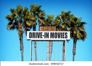 Aged And Worn Vintage Photo Of Old Drive In Movie Sign With Palm Trees                               