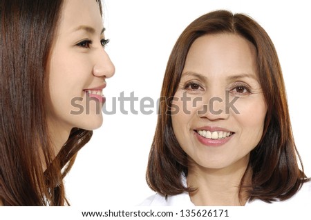 Ageing concept. Asian middle mother and adult daughter face to face, profile side view smiling isolated on white background.