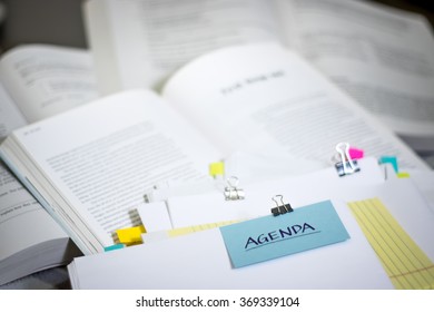 Agenda; Stack of Documents with Large Amount of Reading Material.