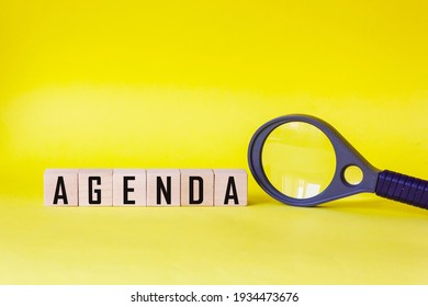 Agenda - Words Made From Wooden Blocks With Letters, List Of Agenda Items Concept, On Yellow Background Magnifier