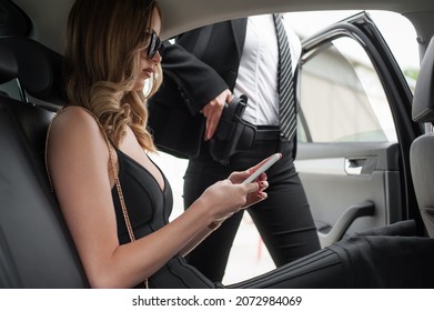 Agent in civilian black suit with gun protect celebrity person in the car. Bodyguard and VIP person security protection. Professional police safeguard