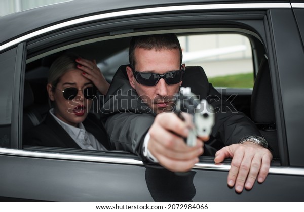 Agent in civilian black suit with gun\
protect celebrity person in the car. Bodyguard and VIP person\
security protection. Professional police\
safeguard