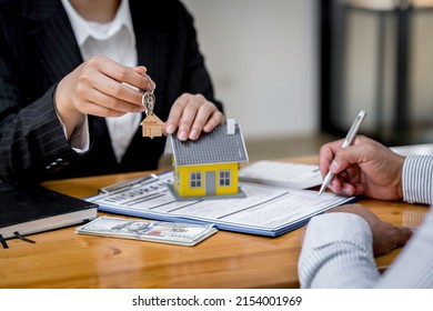 Agent giving house keys to customer after sign agreement property, concerning mortgage loan offer for and house insurance - Shutterstock ID 2154001969
