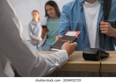 Agent Giving Passport With Ticket To Client At Check-in Desk In Airport, Closeup