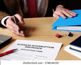 Agent Offers Business Interruption Insurance Application Papers.