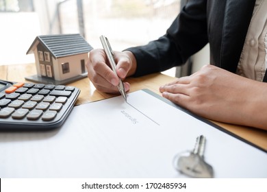 agents working in real estate investment and home insurance signing contracts in accordance with home buying insurance agreements approving purchases for clients.