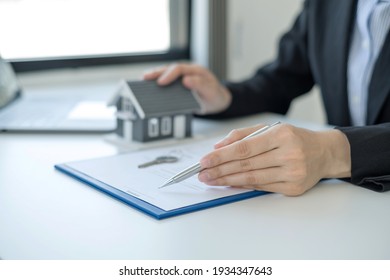 agents working in real estate investment and home insurance signing contracts in accordance with the home buying insurance agreements approving purchases for clients.