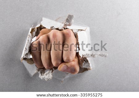aggression concept, wall is broken through by a fist