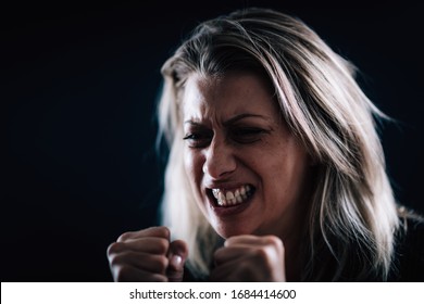 Aggression – portrait of an angry aggressive woman with clenched fists
