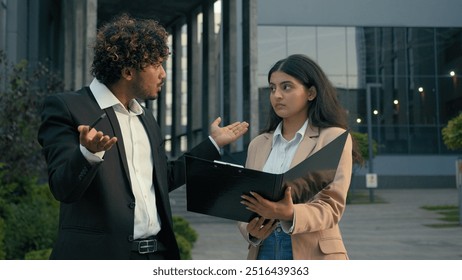 Aggressive anger mad annoyed Indian businessman leader boss man scold talk with anger pointing at contract mistake paper document problem trouble sad upset intern woman businesswoman manager in city - Powered by Shutterstock