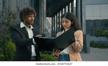 Aggressive anger mad annoyed Indian businessman leader boss man scold talk with anger pointing at contract mistake paper document problem trouble sad upset intern woman businesswoman manager in city - Powered by Shutterstock